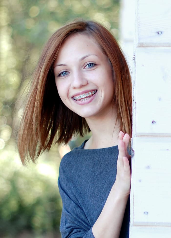 A family of four is laying down with their faces beside each other.
